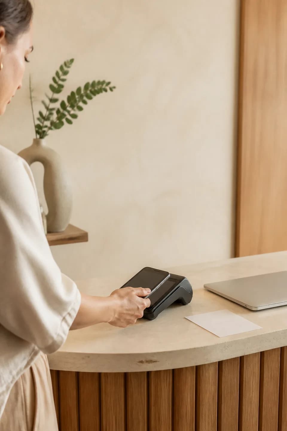 Payments: A provider using a contactless payment terminal beside a work laptop